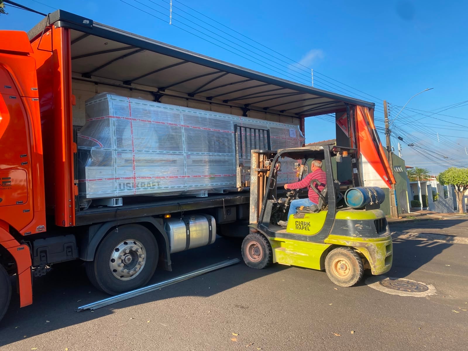 Empilhadeira carregando equipamento embalado dentro do baú de um caminhão da A&G